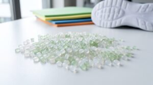 Pellets de resina EVA com placas de espuma coloridas e solado de calçado ao fundo